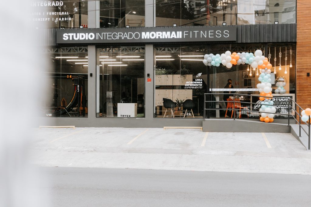 Imagem da fachada do novo Studio Mormaii Morumbi, decorado para o dia de sua inauguração, com balões coloridos.